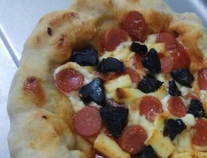 Pizza dengan topping black garlic